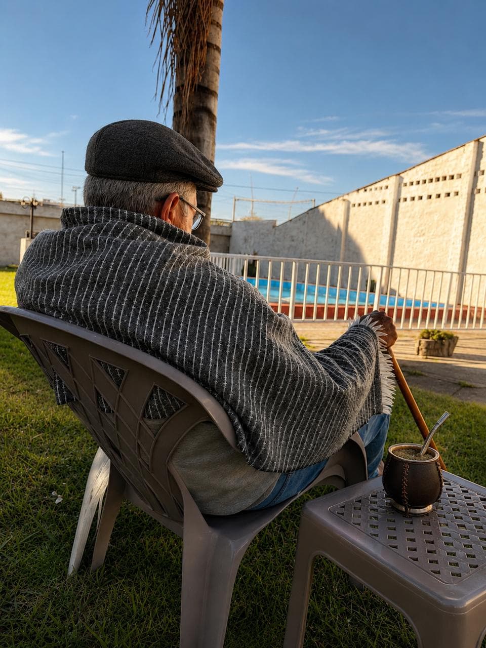 Residente disfrutando un mate en el jardín junto a la pileta